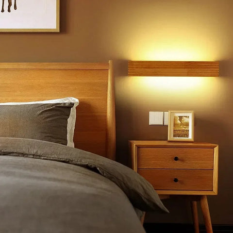 applique murale dans une chambre à côté du lit au dessus d'une table de chevet